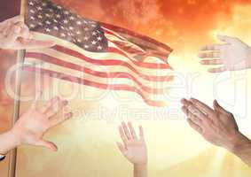 Hands up around fluttering american flag