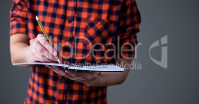 College student mid section with book against grey background