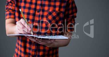 College student mid section with book against grey background