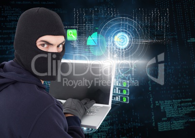 Hacker looking the lens and using a laptop in front of digital background