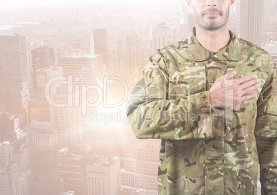 Military with hand on his heart against a city