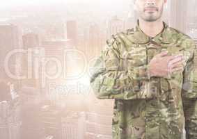 Military with hand on his heart against a city