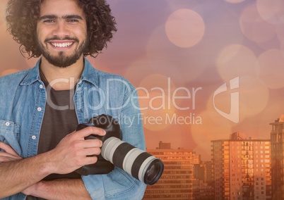 happy young photographer hands folded and camera on hand in front of the city. Overlap with blue and