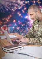 3d Soldier using a laptop with a fireworks in background