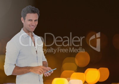 Smiling man texting in lights