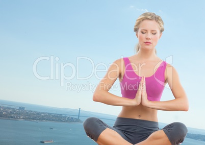 Slanted woman meditating against coastline