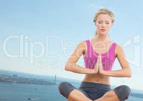 Slanted woman meditating against coastline