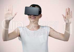 Woman in virtual reality headset against pink background