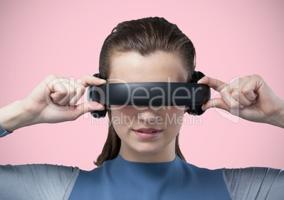 Woman in virtual reality headset against pink background