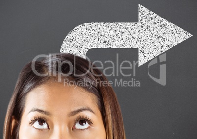 Top of woman's head looking up at white road arrow against grey background