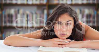 College student at desk against blurry bookshelf