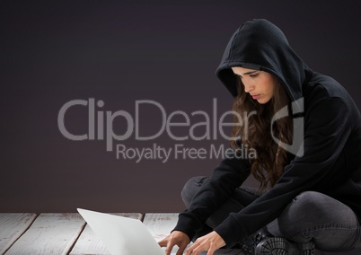 3d Woman hacker using a laptop in front of purple background