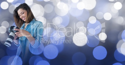 Photographer looking at her camera against glowing background