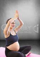 Pregnant woman meditating in grey room