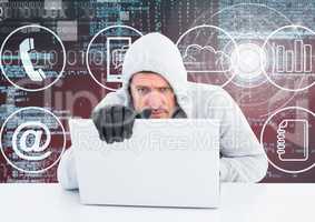 Hacker with gloves using a laptop in front of digital background