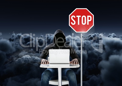 Hacker working on laptop close to a stop board in front of 3D cloudy background