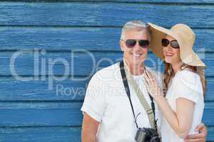 Tourist couple standing on a blue wooden background