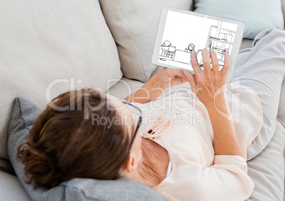 old woman on the sofa with tablet looking new design s for the house