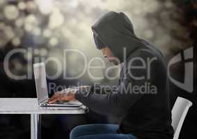 Side view of hacker using a laptop on a table