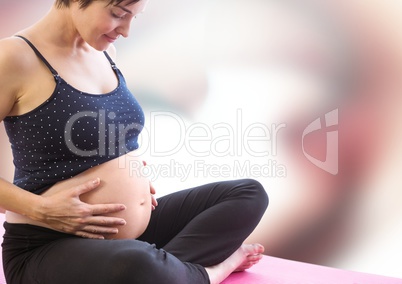 Pregnant woman meditating against blurry red and white abstract background