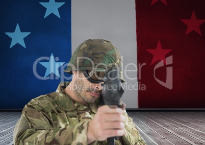 Soldier aiming the lens in front of french flag
