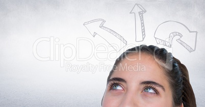 Top of woman's head looking up at upward arrows against white wall