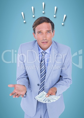 Frustrated business man with money against blue background and exclamation points