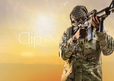Black soldier holding a firearm in desert