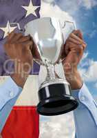 Part of a man holding a cup against fluttering american flag