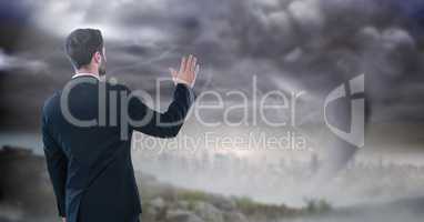 businessman with hand up in storm cityscape