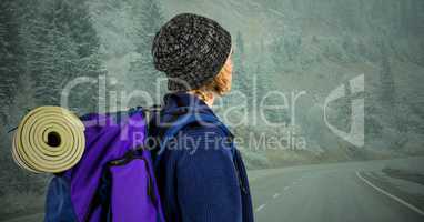 Millennial backpacker looking down misty road