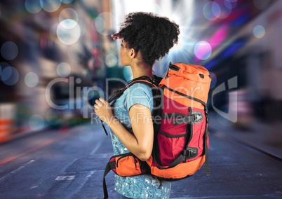 Millennial backpacker searching on blurry street with bokeh and flares