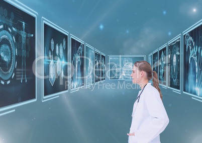 Woman doctor looking at medical interfaces against blue 3d background with flares