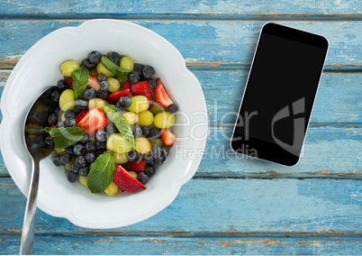 Phone on blue wooden desk with food and copy space on mobile phone