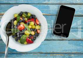 Phone on blue wooden desk with food and copy space on mobile phone