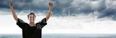 Man in jersey celebrating against grey clouds and water