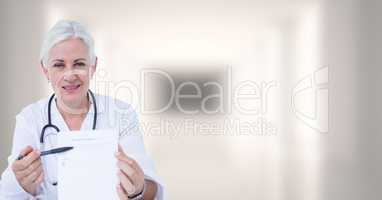 Doctor holding clipboard against blurry white hallway