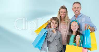 Family with shopping bags against blurry blue abstract background