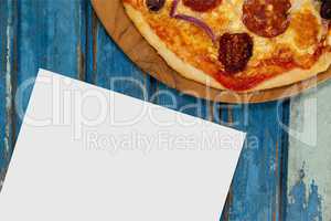 Blank card on blue wooden desk with food and copy space on paper