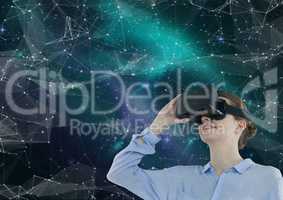 Woman in VR headset looking up against green and purple space background with interface