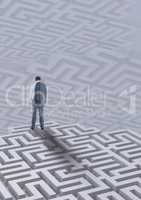 Man standing on a 3D maze against background with mazes