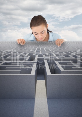 Woman looking down to a 3d maze against blue sky