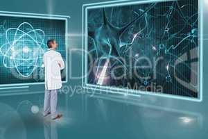 Man doctor looking at 3d medical interfaces against blue background with flares