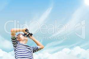 Boy looking through binoculars against sky