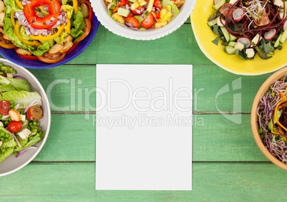 Blank card on green wooden desk with food and copy space on paper