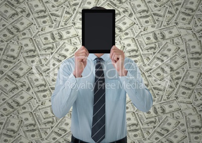 Business man holding tablet over face against money backdrop