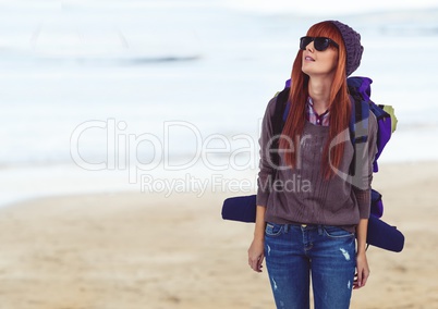 Millennial backpacker in sunglasses against blurry beach