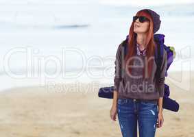 Millennial backpacker in sunglasses against blurry beach
