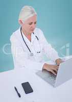 Doctor at laptop against blue background