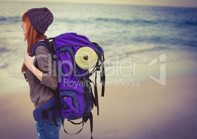 Millennial backpacker on blurry beach